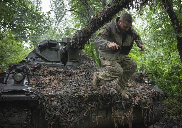 Ukrainian soldier jumping off the German self-propelled Panzerhaubitze 2000 artillery